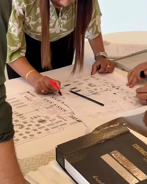 The Xena team marking up floor plans beside a material sample book